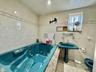 Full bathroom with a whirlpool tub and tile walls