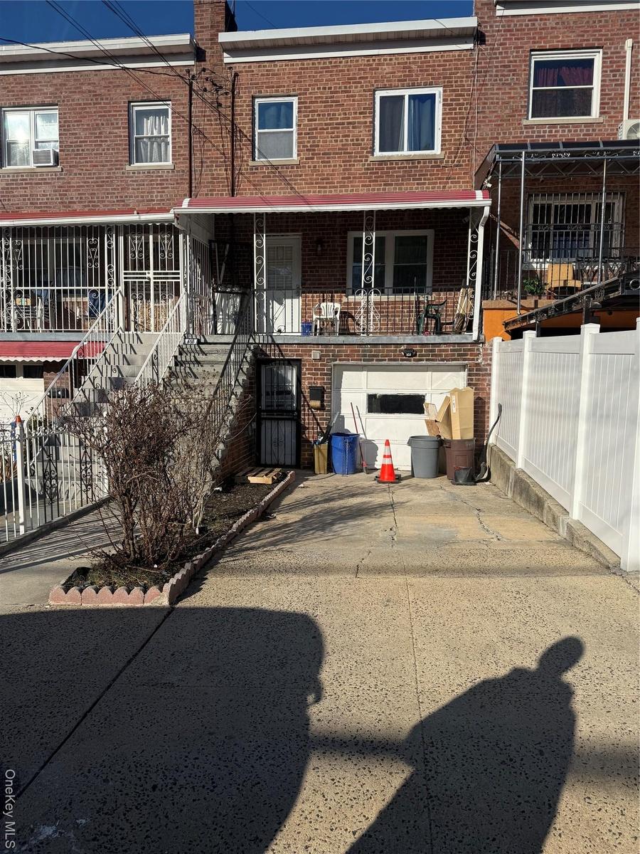 Rear view of property with brick siding, fence, stairs, cooling unit, and driveway
