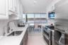 Kitchen with stainless steel appliances, white cabinets, a sink, and decorative backsplash