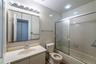 Hall Full bathroom with tile walls, vanity, bath / shower combo with glass door