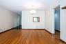 Empty room with a chandelier and dark wood-style flooring
