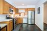 Kitchen with appliances with stainless steel finishes, stone tile floors