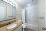 Full bath featuring shower / bath combo with shower curtain, vanity, and tile walls