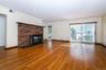 living room with wood burning fireplace, plenty of natural light, a fireplace, wood finished floors, and recessed lighting