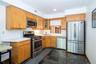 Kitchen with appliances with stainless steel finishes, light countertops, recessed lighting, stone tile flooring,