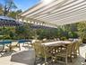 View of Pool Side Patio with Table and Awning