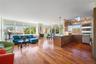 Kitchen featuring open floor plan, dark wood finished floors, pendant lighting, stainless steel appliances, and a peninsula