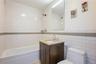 Bathroom with tile walls, vanity, and washtub / shower combination