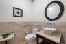 Half bath with a wainscoted wall, tile walls, and vanity