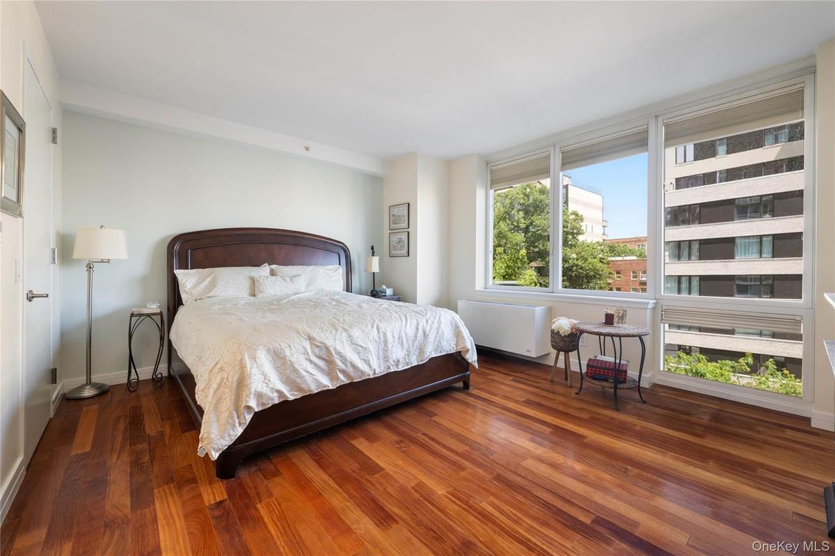 Bedroom with dark wood-type flooring and radiator heating unit