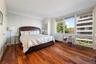 Bedroom with dark wood-type flooring and radiator heating unit