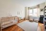 Bedroom featuring light wood-style flooring and a nursery area