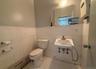 Bathroom featuring baseboard heating, sink, tile walls, tile patterned flooring, and toilet