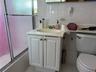 Full bathroom with vanity, combined bath / shower with glass door, and tile walls