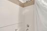 Bathroom view of shower / bathtub combination with curtain