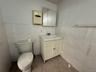 Bathroom with tile patterned flooring, vanity, toilet, and tile walls