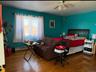 Bedroom with hardwood / wood-style flooring, baseboard heating, and ceiling fan