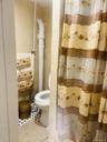 Full bath with curtained shower, tile walls, and tile patterned flooring