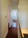 Hallway with an upstairs landing and dark wood-style floors