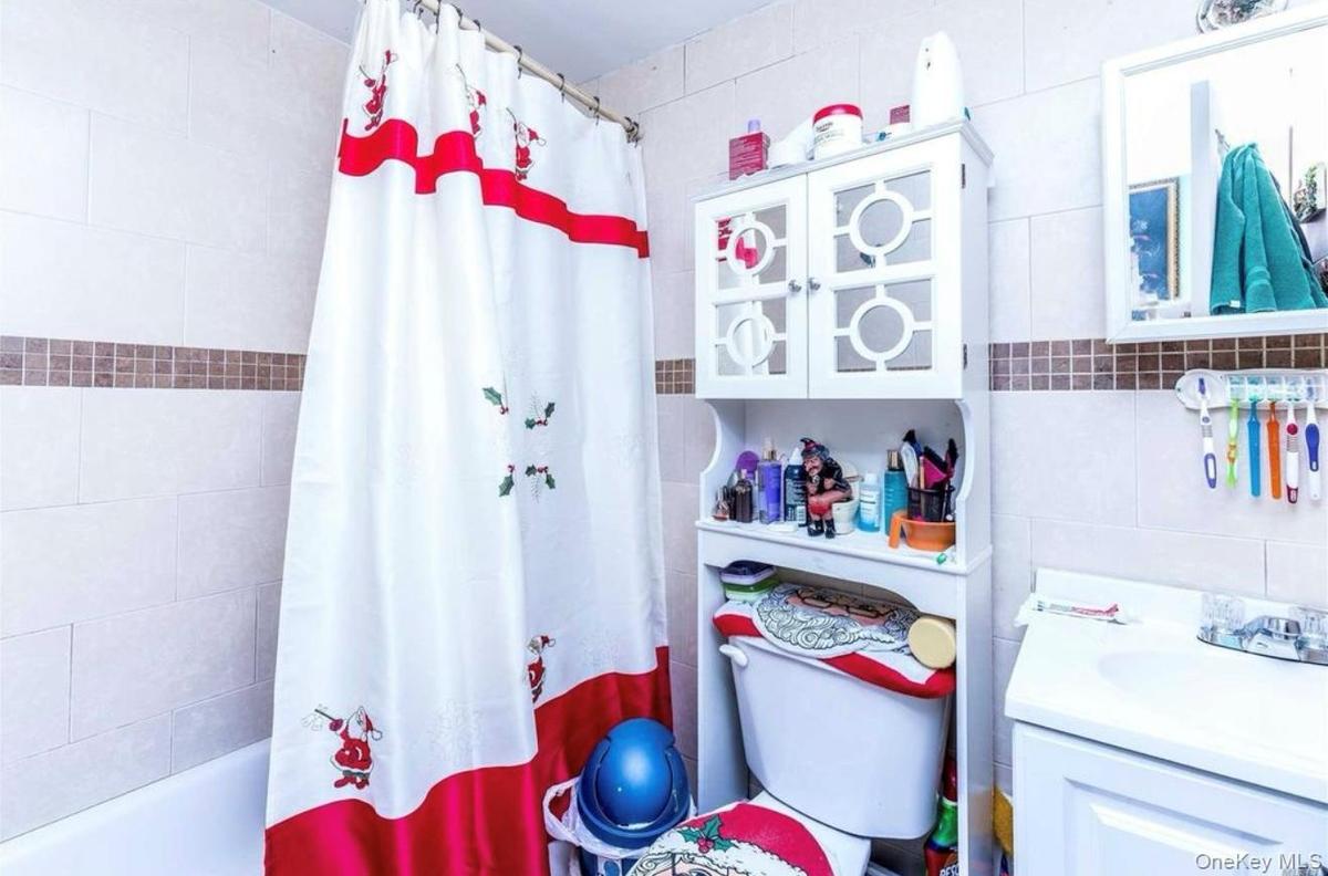 Full bathroom featuring tile walls, vanity, and shower / tub combo
