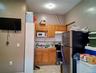Kitchen featuring backsplash, appliances with stainless steel finishes, light countertops, under cabinet range hood, and light tile patterned flooring