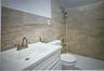 Full bath with vanity, a tile shower, and tile walls
