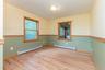 Unfurnished room with baseboard heating, wood finished floors, and baseboards