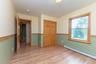 Unfurnished bedroom featuring a baseboard radiator, light wood-style flooring, a closet, and baseboards