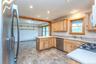 Kitchen featuring appliances with stainless steel finishes, baseboard heating, light brown cabinets, a sink, and recessed lighting