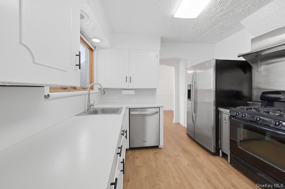 Stainless Steel appliances, modern black cabinet hardware, new LVP flooring