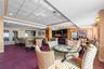 Common area featuring multiple seating arrangements, a full kitchen with stainless steel appliances, recessed lighting, and wall sconces