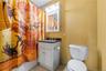 Bathroom featuring a white vanity with a dark countertop, an overhead vanity light, an integrated medicine cabinet, and a toilet