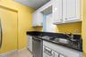 Kitchen featuring white cabinetry, dark countertops, a stainless steel dishwasher, and a stainless steel sink with a pull-out faucet