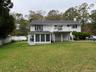 Back of property with stairway, a chimney, and a wooden deck