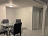 Dining space with a paneled ceiling and dark aggregate flooring