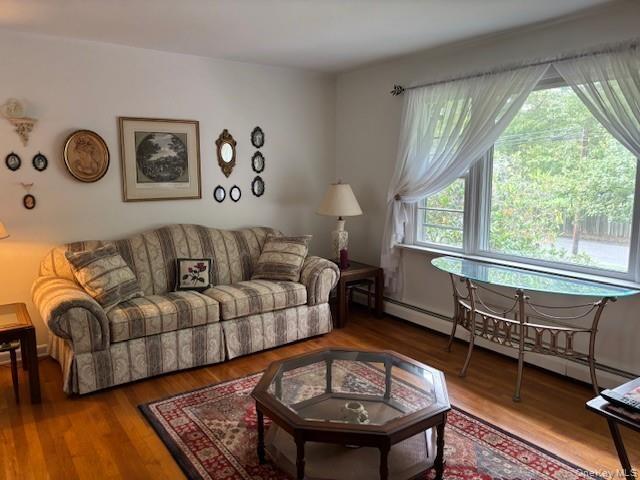 Living area with baseboard heating and wood finished floors