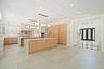 Kitchen with light brown cabinetry, decorative light fixtures, glass insert cabinets, light stone counters, and decorative backsplash