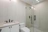 Bathroom with a stall shower, vanity, tile walls, and recessed lighting