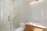 Bathroom featuring vanity, a stall shower, and tile walls
