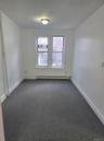 Empty room with carpet flooring and a baseboard radiator