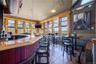 Bar area featuring tile patterned flooring, wainscoting, and vaulted ceiling