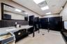 Bathroom with a drop ceiling, double vanity, wood walls, and a wainscoted wall