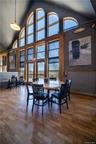 Dining room with high vaulted ceiling, wood finished floors, and a baseboard radiator