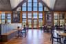 Home office with wood finished floors, healthy amount of natural light, wainscoting, and high vaulted ceiling