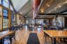 Dining room featuring wood finished floors, rail lighting, and a high ceiling
