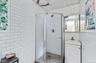 Full bathroom with tile walls, a stall shower, and vanity
