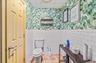 Bathroom with a paneled ceiling, wallpapered walls, a wainscoted wall, tile walls, and tile patterned floors