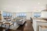 Living room featuring dark wood-style flooring, recessed lighting, and a water view