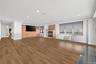 Unfurnished living room featuring a fireplace, wood finished floors, ornamental molding, and brick wall