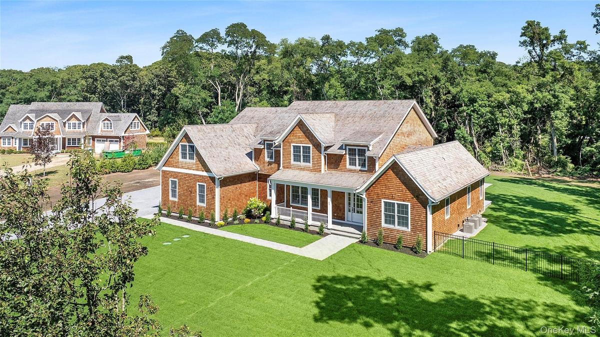 Shingle-style home featuring a porch and roof with shingles